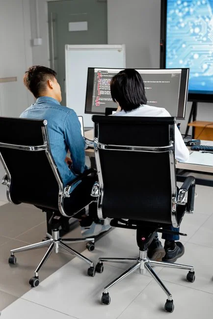 Un espace de travail élégant avec un ordinateur portable et des écrans montrant un logiciel de conception.