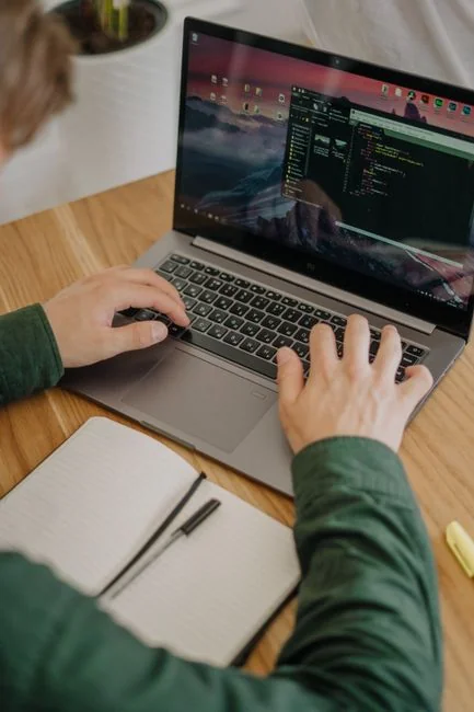 Close-up of hands interacting with a shopping website on a laptop screen indoors.